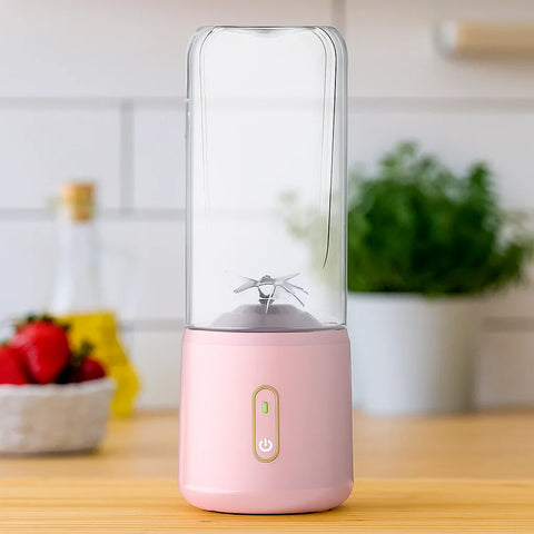 Pink protein shaker bottle with transparent Tritan body and built-in mixing blades on wooden kitchen countertop.