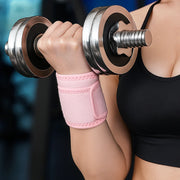 Close-up of a person wearing a pink padded cotton wrist support belt while lifting a metal dumbbell, providing wrist stabilization and support during weightlifting.